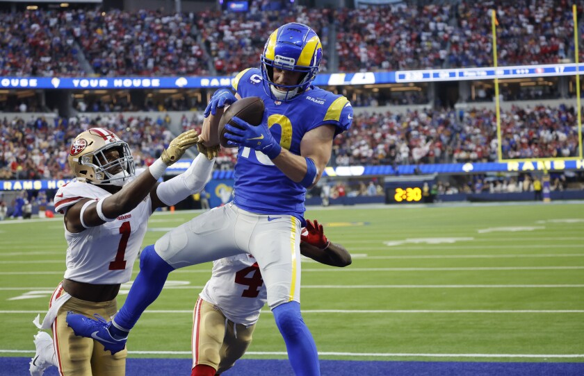 The Rams' Cooper Kupp (10) catches a touchdown pass against 49ers defensive backs Jimmie Ward (1) and Emmanuel Moseley (4). 