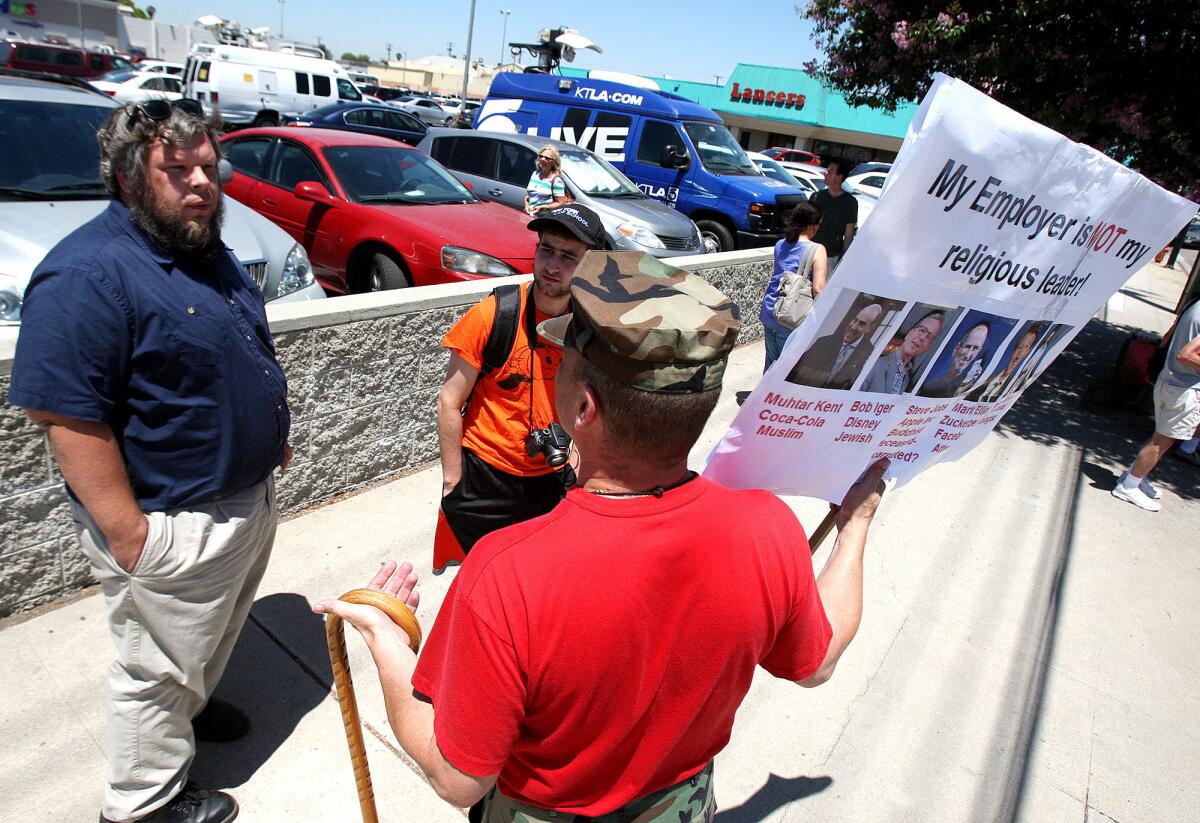 A group of men at a protest, of mostly women, in front of the newly opened Hobby Lobby in Burbank on Monday, July 7, 2014. The protesters have taken issue with a lawsuit filed by Hobby Lobby for the right to strike some of the contraceptive options available through Obamacare that conflicts with the companies religious philosophy, a lawsuit that escalated to the Supreme Court of the United States who sided with Hobby Lobby.