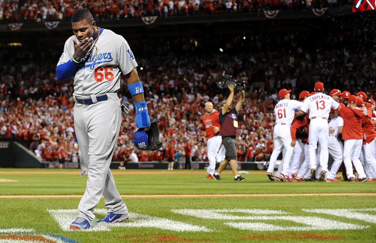 Dodgers pinch-runner Yasiel Puig walks off the field as the Cardinals celebrate their victory in Game 4 of the National League division series last year.
