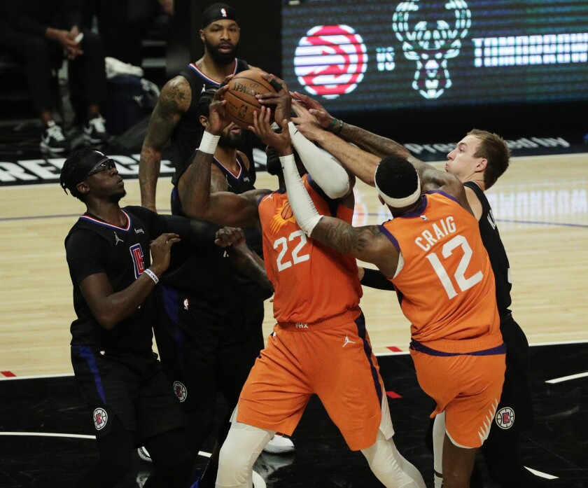 A scrum of basketball players fighting for the ball.