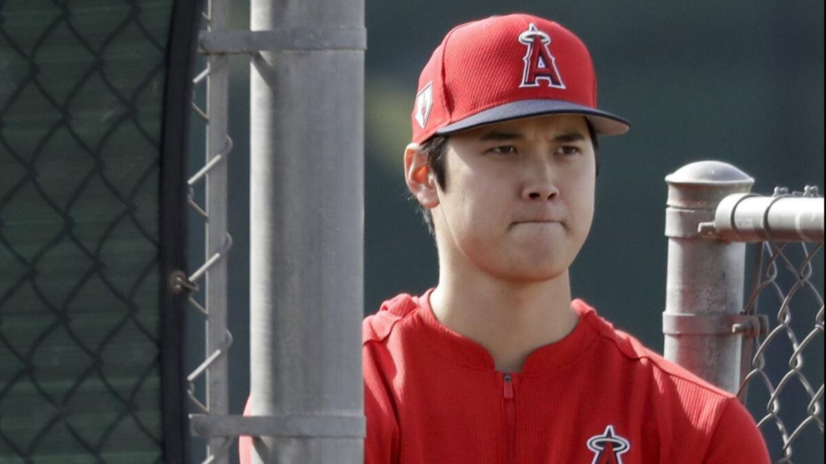 Shohei Ohtani watches Angels pitchers throw during a spring training practice session on Feb. 15 in Tempe, Ariz. Ohtani is moving closer to returning to the Angels.
