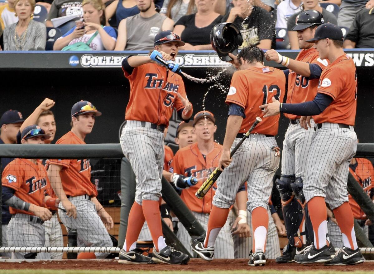 Cal State Fullerton's Tim Richards Jr. gets doused with water after scoring against Vanderbilt during College World Series on June 14.