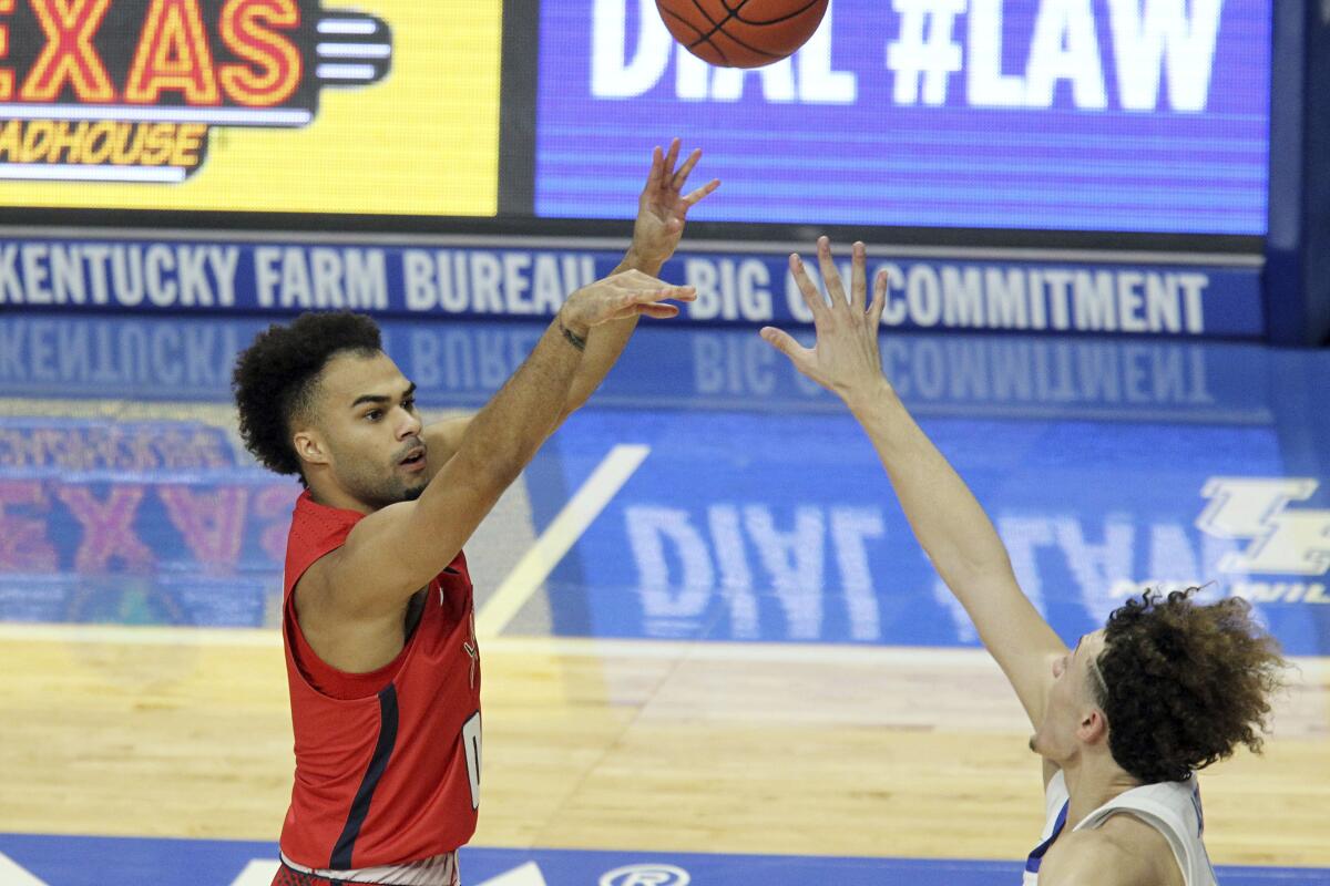 Richmond's Jacob Gilyard shoots while defended by Kentucky's Devin Askew.