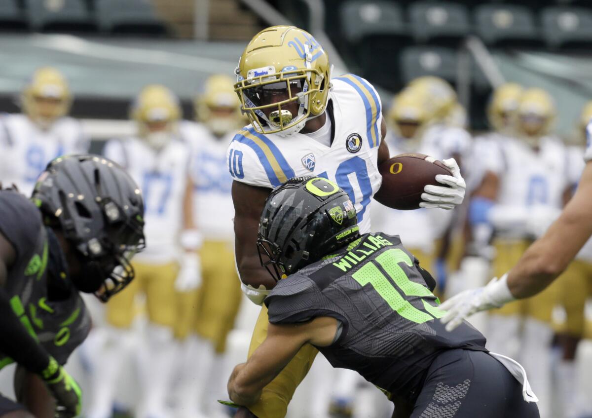 UCLA's Demetric Felton Jr. is tackled by Oregon's Bennett Williams during the first quarter.