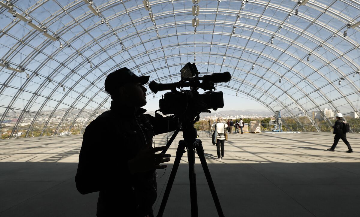 Members of the media check out the glass-domed terrace atop architect Renzo Piano's concrete sphere during a Friday walk-through at the Academy Museum of Motion Pictures in L.A.