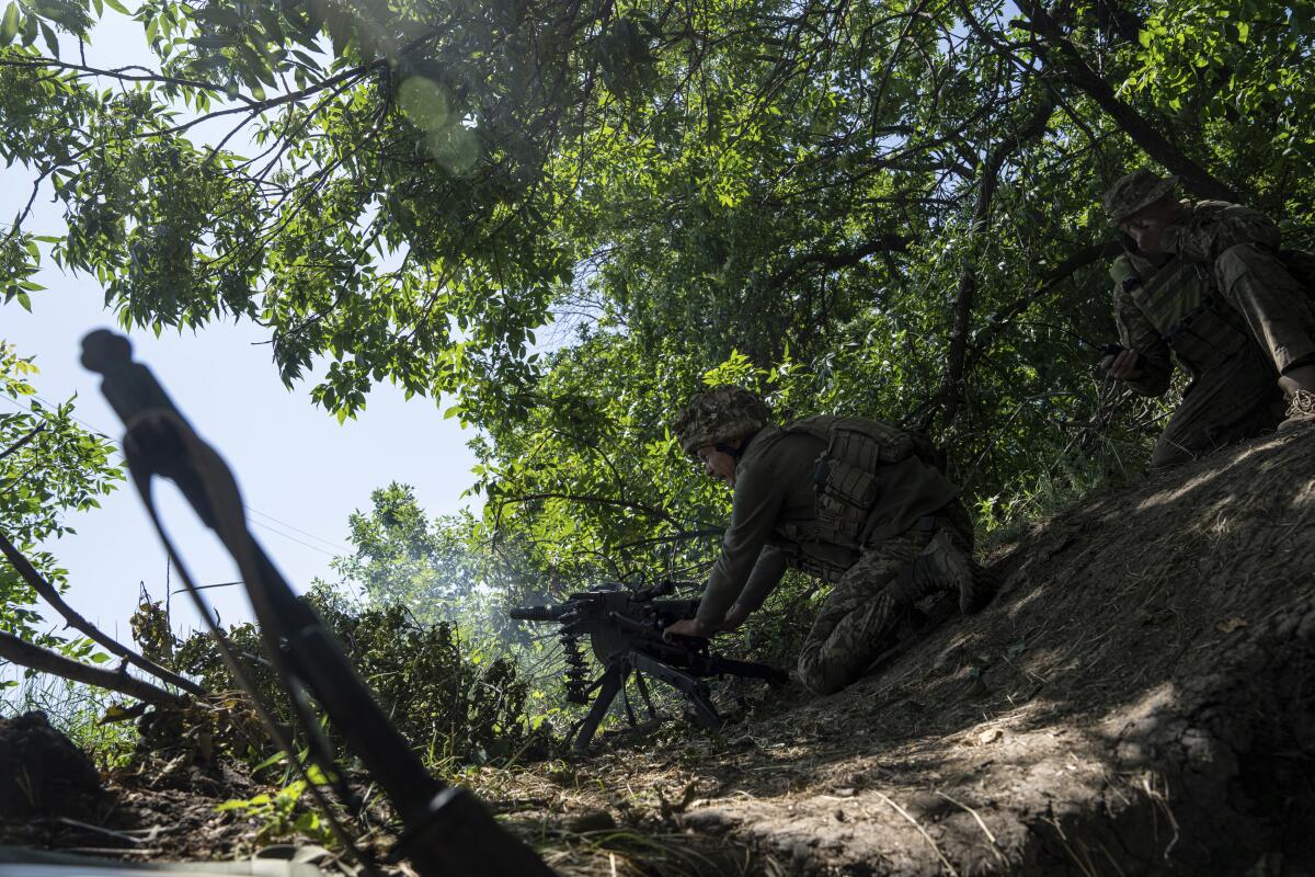 FILE - A Ukrainian marine of 35th brigade fires by automatic grenade launcher AGS-17 towards Russian positions on the outskirts of Avdiivka, Ukraine, on June 19, 2023. Ukrainian troops are under intense pressure from a determined Russian effort to storm the strategically important eastern Ukraine city of Avdiivka, officials say. Kyivs army is struggling with ammunition shortages as the Kremlins forces pursue a battlefield triumph around the two-year anniversary of Moscows full-scale invasion and ahead of a March presidential election in Russia. (AP Photo/Evgeniy Maloletka, File)