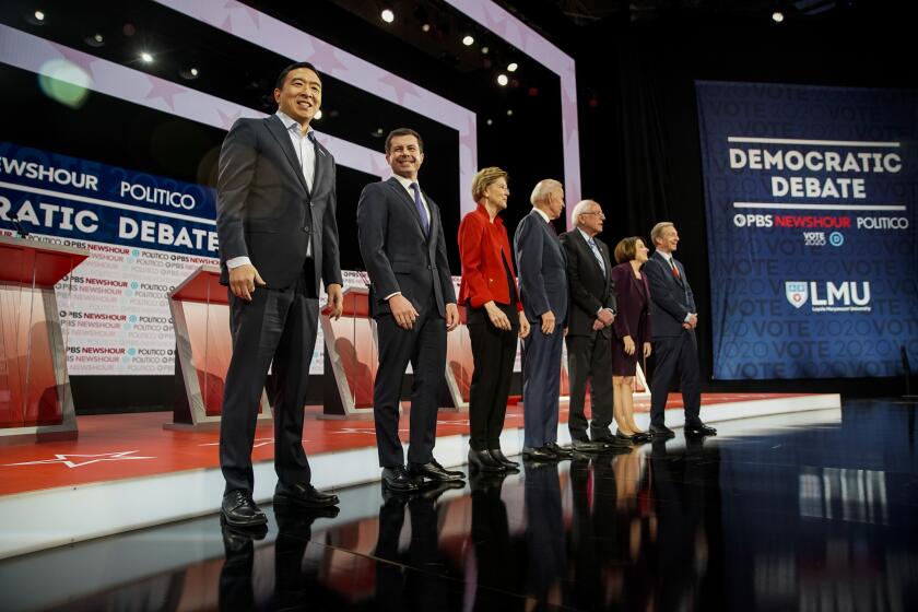 LOS ANGELES, CALIF. - DECEMBER 19: Entrepreneur Andrew Yang, South Bend, Indiana, Mayor Pete Buttigieg Massachusetts Sen. Elizabeth Warren, Former Vice President Joe Biden, Vermont Sen. Bernie Sanders, Minnesota Sen. Amy Klobuchar and Businessman Tom Steyer on stage before the start of the sixth DNC Debate at Loyola Marymount University on Thursday, Dec. 19, 2019 in Los Angeles, Calif. (Kent Nishimura / Los Angeles Times)