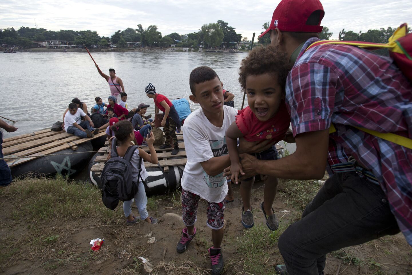 A group of Honduran migrants arrives to the Mexican side of the border after crossing the Suchiate River aboard a raft made out of tractor inner tubes and wooden planks, on the the border with Guatemala, in Ciudad Hidalgo, Mexico.