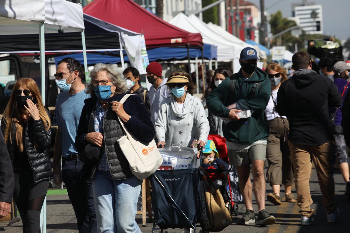 Customers wearing masks shop for produce at the Santa Monica Farmers Market.