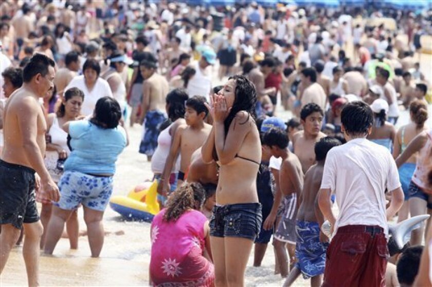 Tourists, mostly from Mexico City, pack the Caletilla beach in Acapulco, Mexico Friday May, 1, 2009. Scared with swine flu contagion, the Mayor of this resort city is telling tourists from Mexico City to go home.(AP Photo/Javier Verdin)