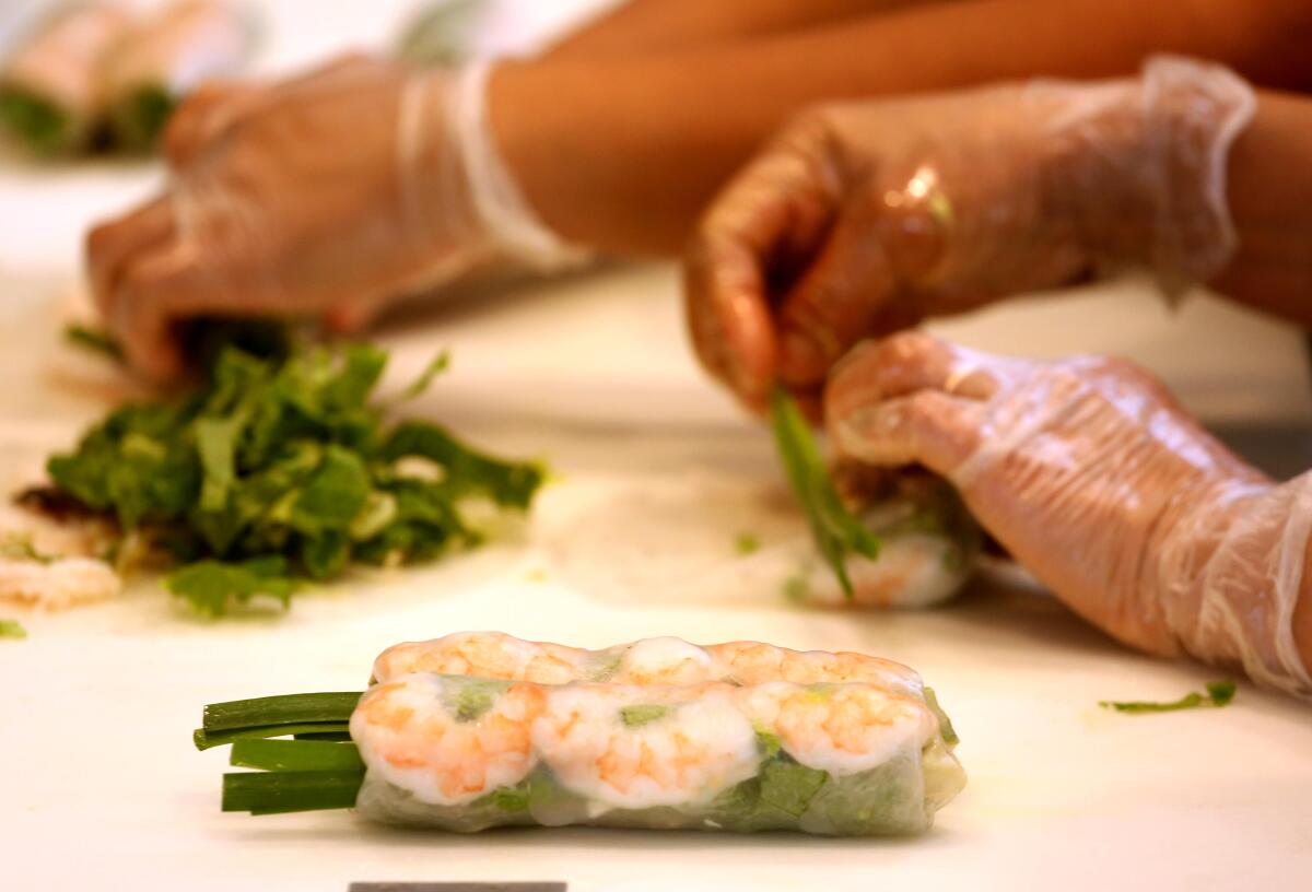 Kitchen workers prepare fresh shrimp and pork rolls at Brodard Restaurant.