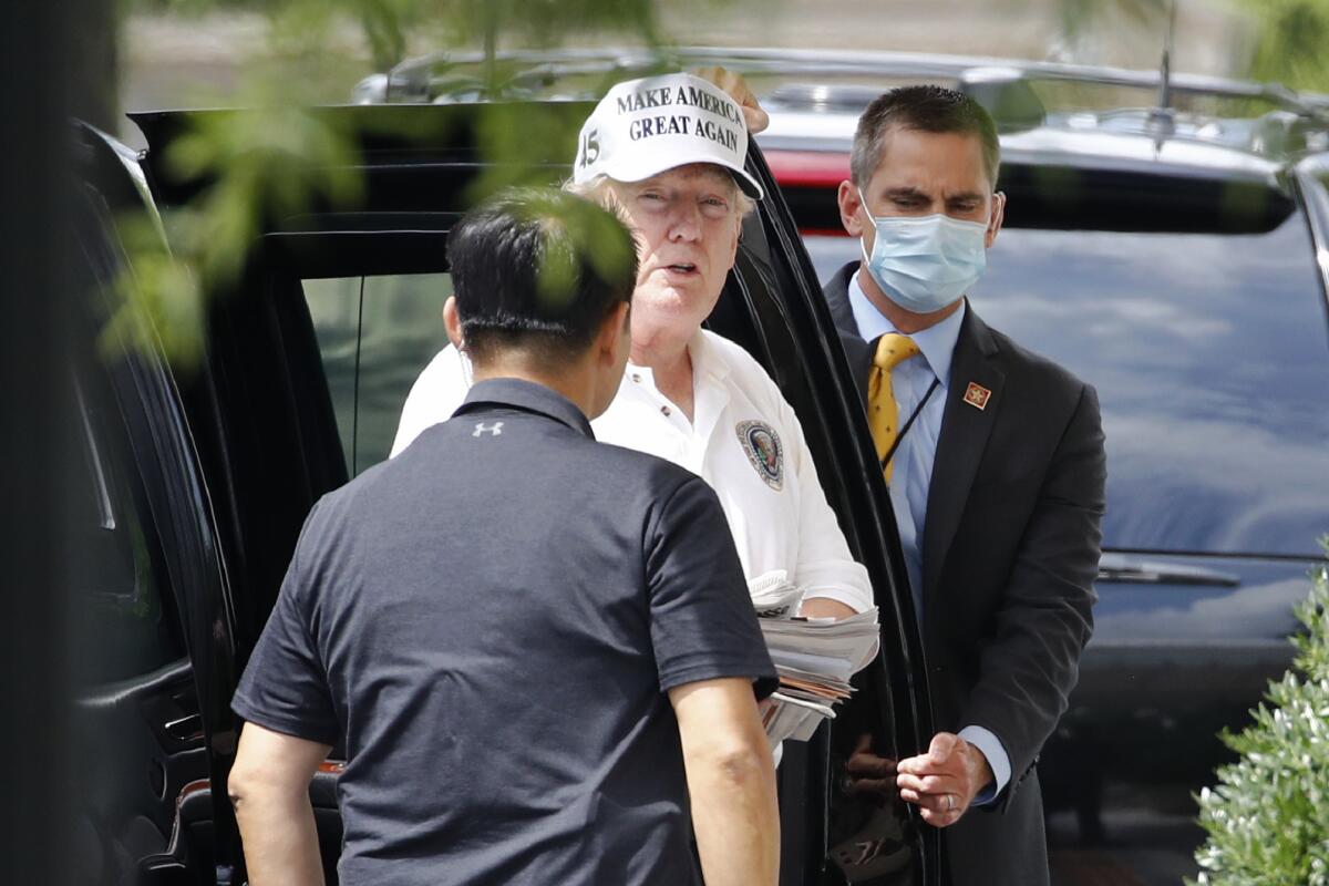 President Trump returns from his golf course on Saturday. 