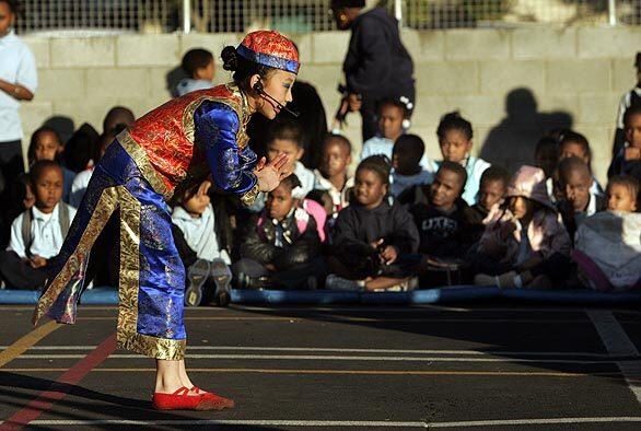 Yi Wang, 9, bows during a performance by the Tianjin Cathay Future Children's Art Troupe of China for students at the Watts Learning Center.