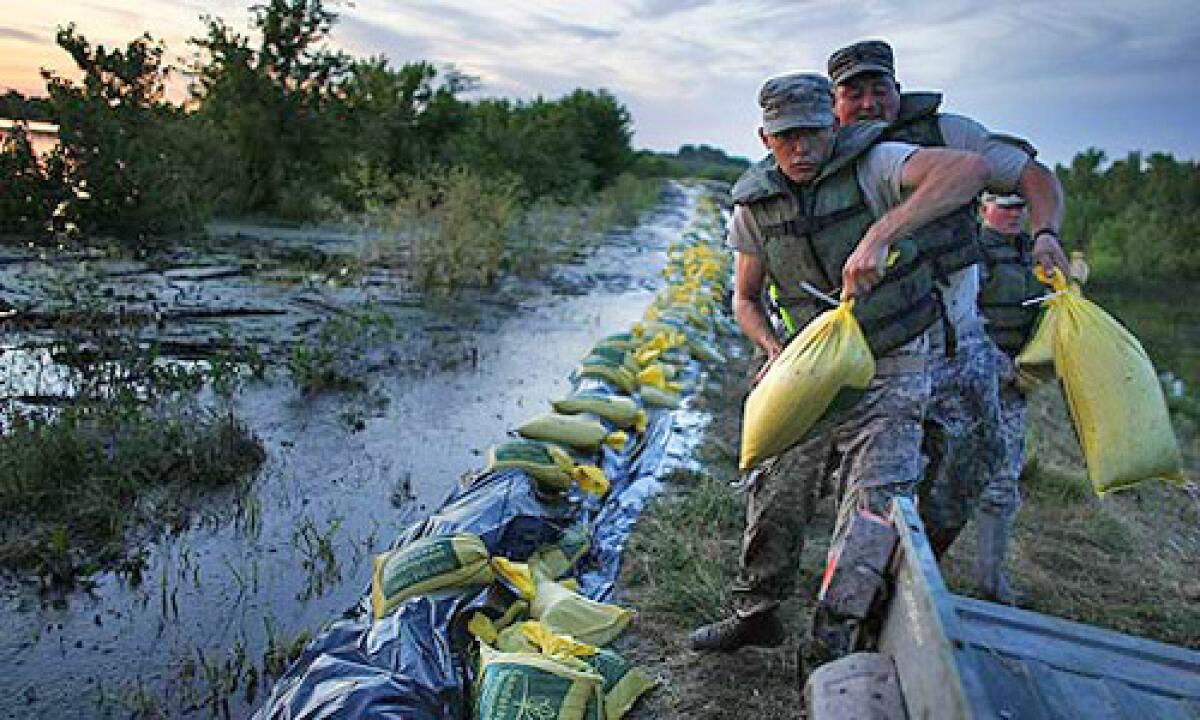 Army National Guard members load sandbags into an ATV as they fight to keep a levee near the flooding Mississippi River from washing out. Many Midwestern towns could not afford the amount the Army Corps of Engineers would have required them to chip in for flood-protection projects.