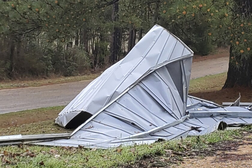A crumpled tin roof on the ground.