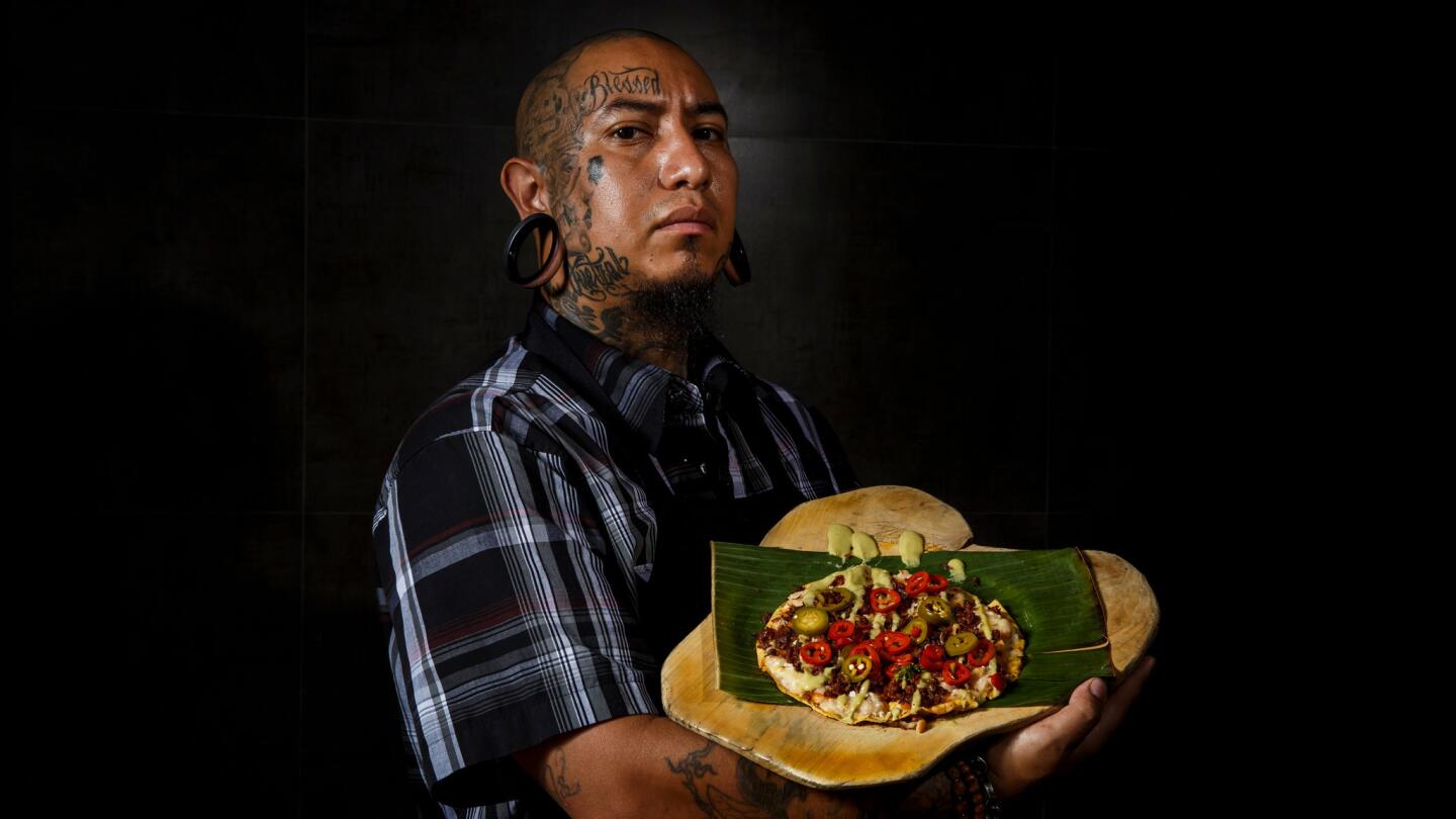 Chef Eddie Garcia displays tlayuda de chorizo y chapulines (tlayudas with crispy chorizo and toasted grasshoppers) at Cocina Condesa in Los Angeles.