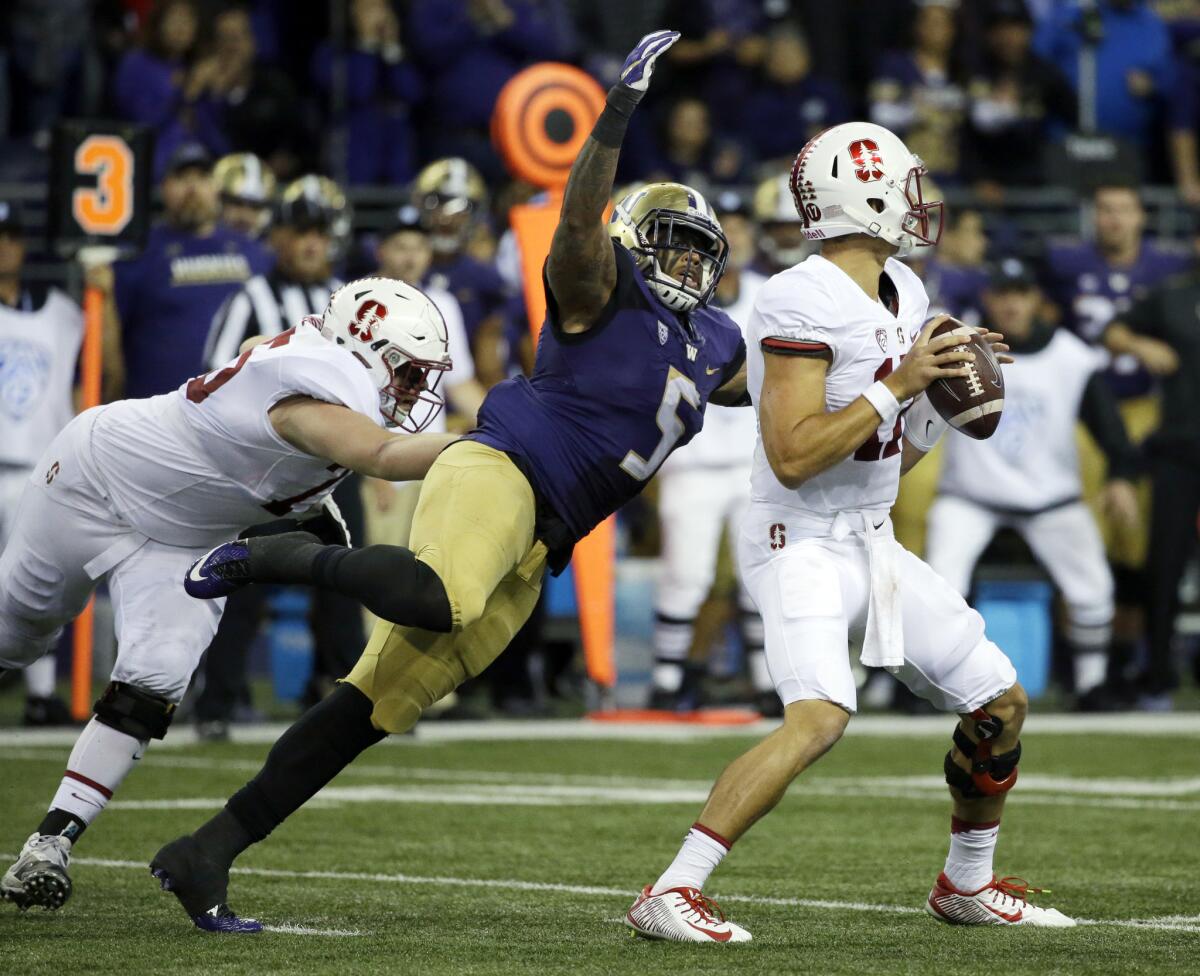 Washington linebacker Joe Mathis (5) tackles Stanford quarterback Ryan Burns, right, in the first half on Sept. 30.