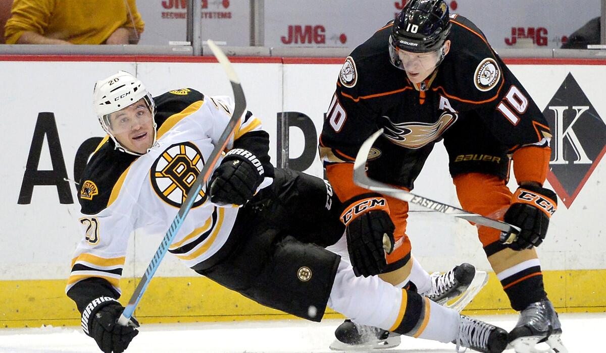 Ducks right wing Corey Perry (10), knocking down Boston's Daniel Paille with a check, was injured in the first period of Friday night's game in Minnesota.