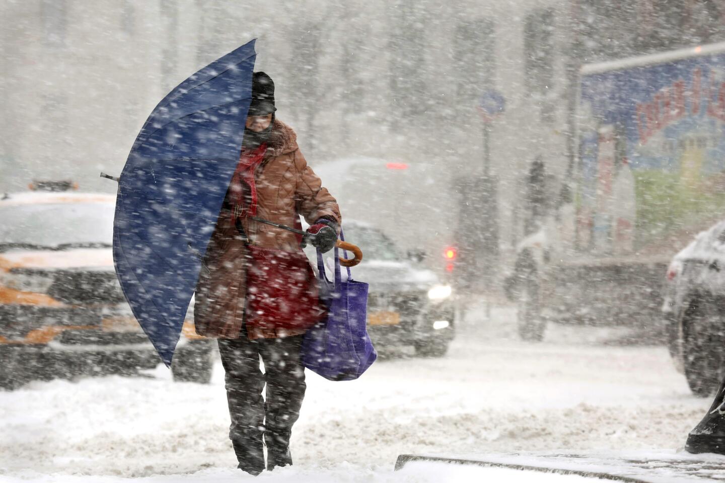 A person walks with an umbrella to block the wind and snow in Manhattan as a winter storm pounds New York on Jan. 4.