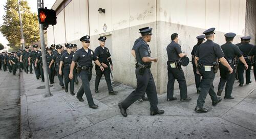 NEW PRESENCE: LAPD officers walk to 6th Street from the Central Division Station. Chief William J. Bratton said a new compromise on skid row tents has been reached with the ACLU.