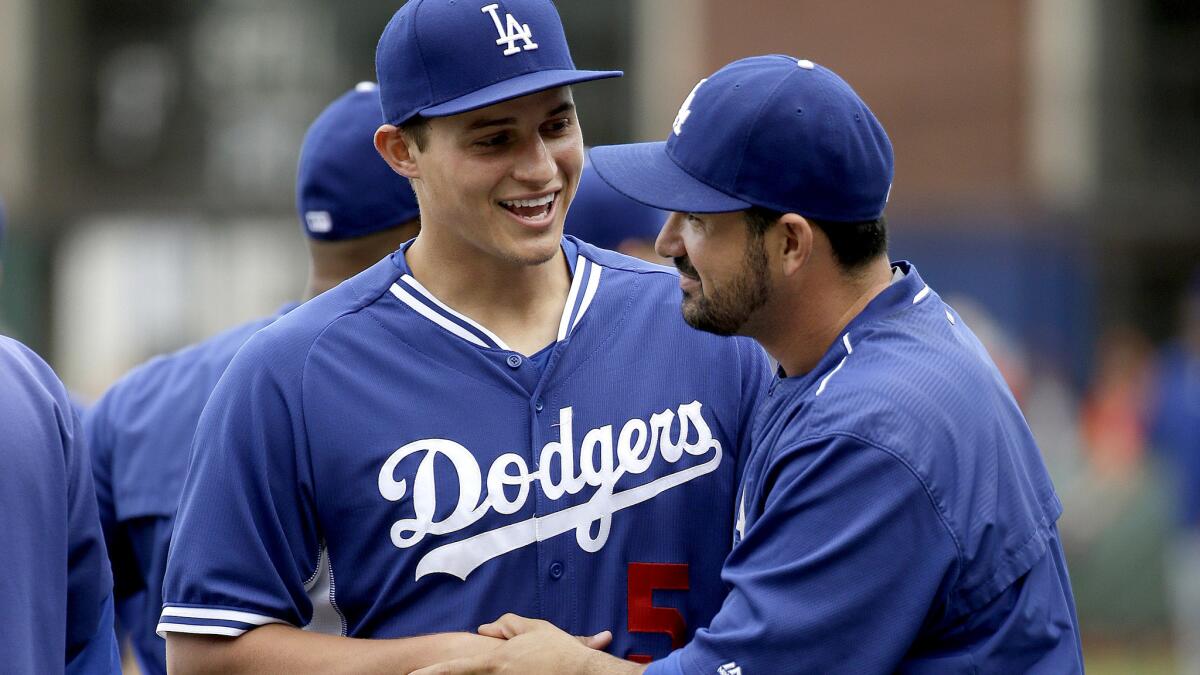 Corey Seager, being greeted by first baseman Adrian Gonzalez as they warm up before a game, appears to be the Dodgers' everyday shortstop heading into the playoffs.