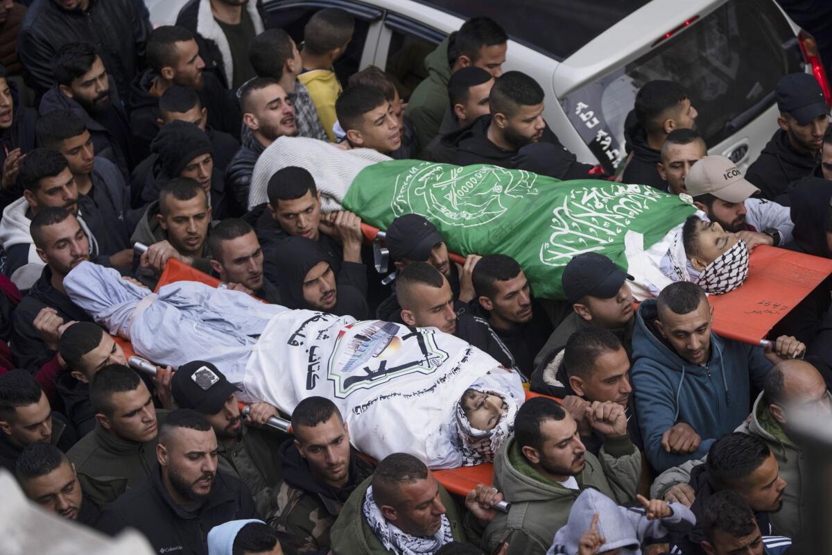 Mourners carrying the bodies of two Palestinian men