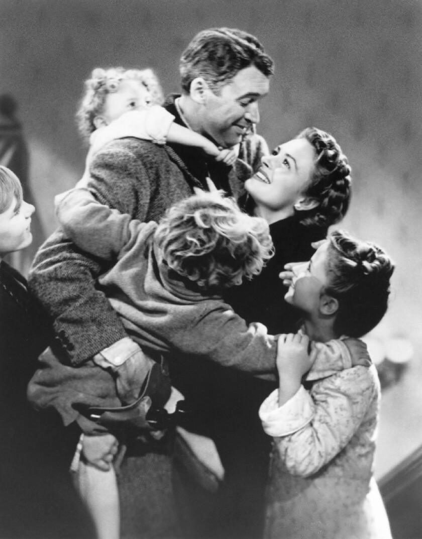 This image released by Paramount Home Entertainment shows child actor Karolyn Grimes on the back of Jimmy Stewart in a scene from the holiday classic "It's a Wonderful Life," also starring Donna Reed. The film is celebrating its 75th anniversary. (Paramount Home Entertainment via AP)