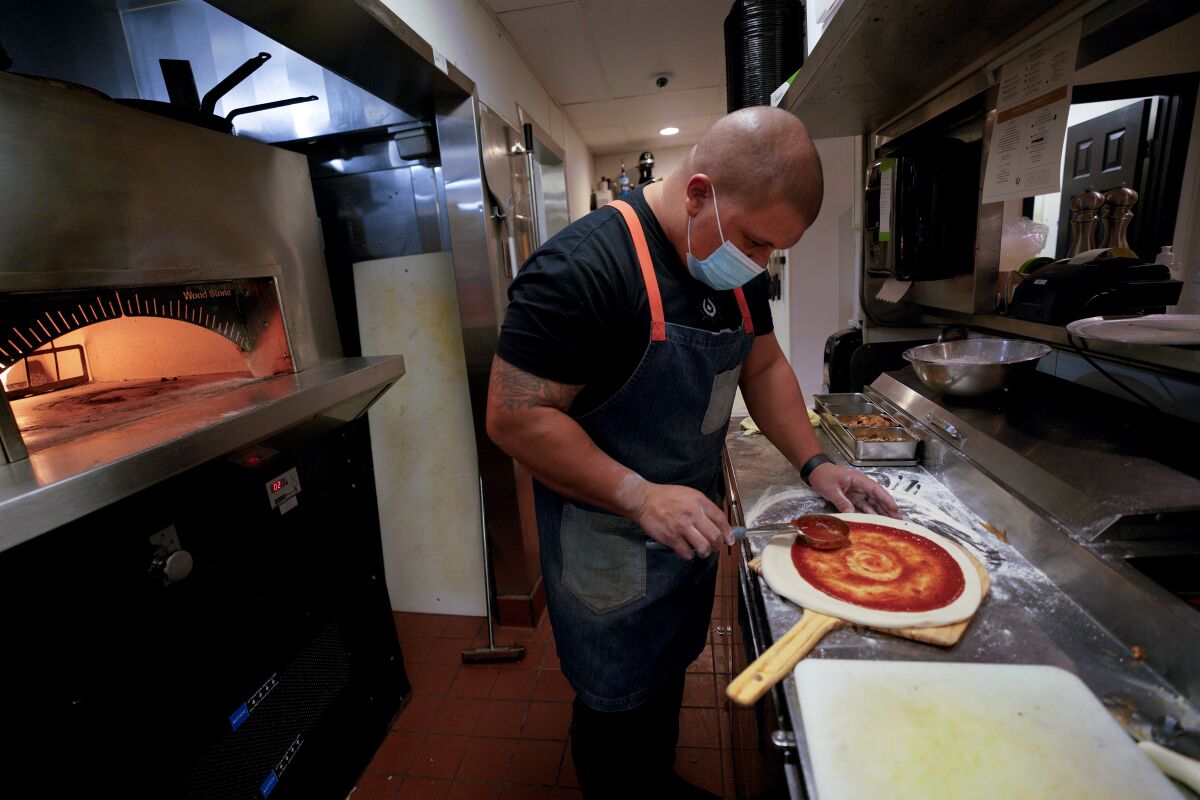 Brad Wise, chef and owner of Trust Restaurant Group, prepares a pizza Rare Society Steakhouse in Hillcrest 