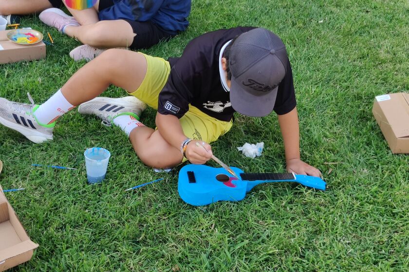 A Dwyer Middle School student puts the finishing touches on while painting a ukulele. The project was funded through a $1,000 "mini-grant."