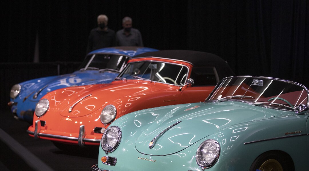 Automotive enthusiasts view rare classic Porsche sports cars on display in the Galpin Hall