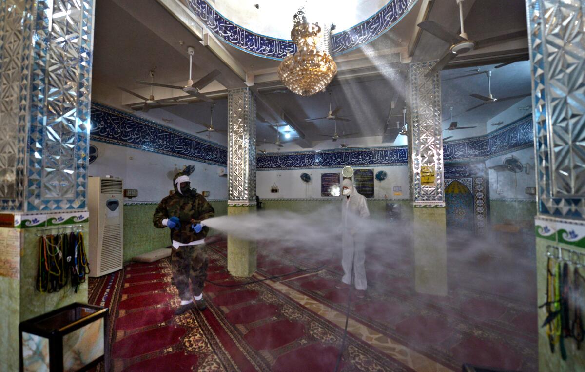 Civil defense workers in Iraq disinfect a mosque. 