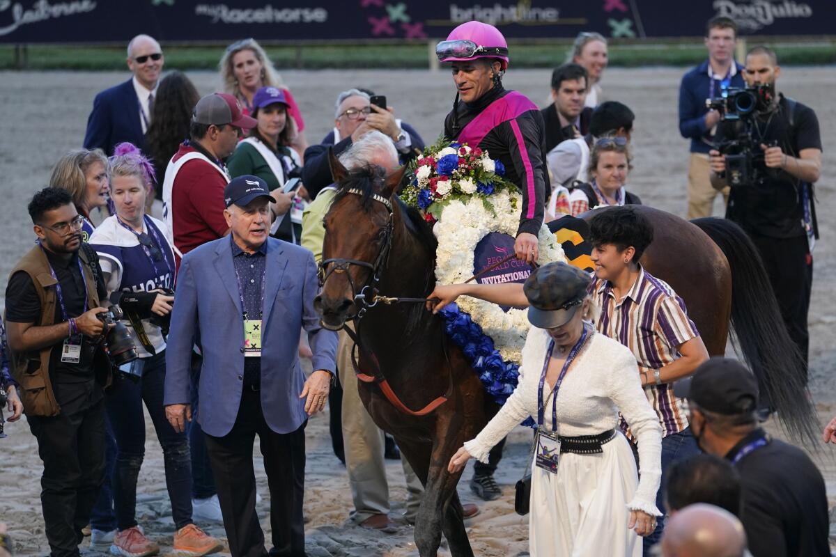Art Collector owner Bruce Lunsford, left in blazer, celebrates in the winner's circle.
