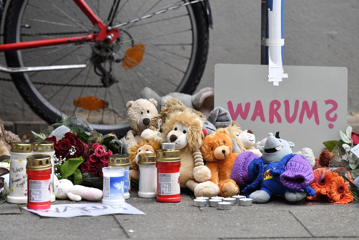 FILE-Teddy bears and candles are pictured at the entrance of an apartment building where five dead children were found in Solingen, Germany, Friday, Sept. 4, 2020. A 28-year-old German mother has been found guilty and sentenced to life in prison for the murder of five of her six children at their home in the western city of Solingen. (AP Photo/Martin Meissner)