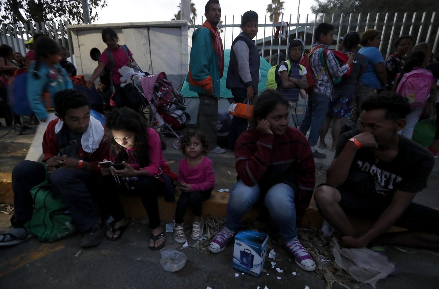 Migrants who are part of the caravan that has made its way from Honduras wait for shelter outside the Benito Juarez Sports Center in Tijuana on Nov. 15.