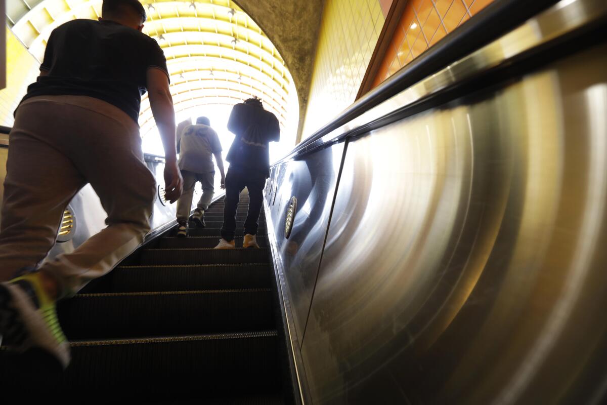 Commuters make their way up an escalator after arriving at the North Hollywood Metro station in 