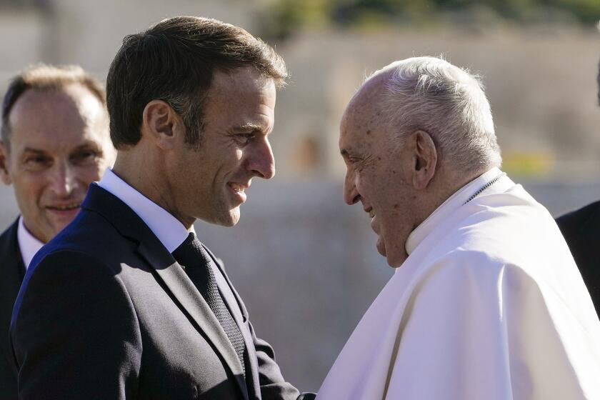 Pope Francis is welcomed by French President Emmanuel Macron as arrives at the final session of the "Rencontres Mediterraneennes" meeting at the Palais du Pharo, in Marseille, France, Saturday, Sept. 23, 2023. Francis, during a two-day visit, will join Catholic bishops from the Mediterranean region on discussions that will largely focus on migration. (AP Photo/Alessandra Tarantino)