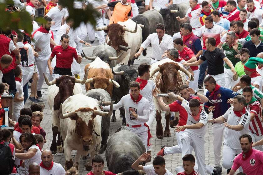 Participants run next to Jose Escolar Gil fighting bulls on the third bullrun of the San Fermin festival in Pamplona, Spain.