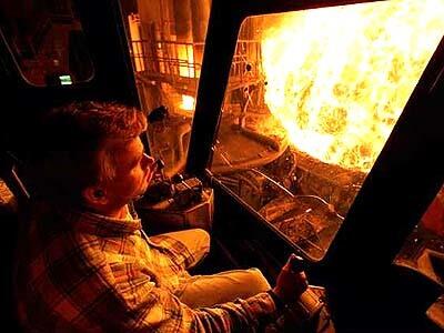 Scrap metal being lowered into a melting pot sends out an intense blast.