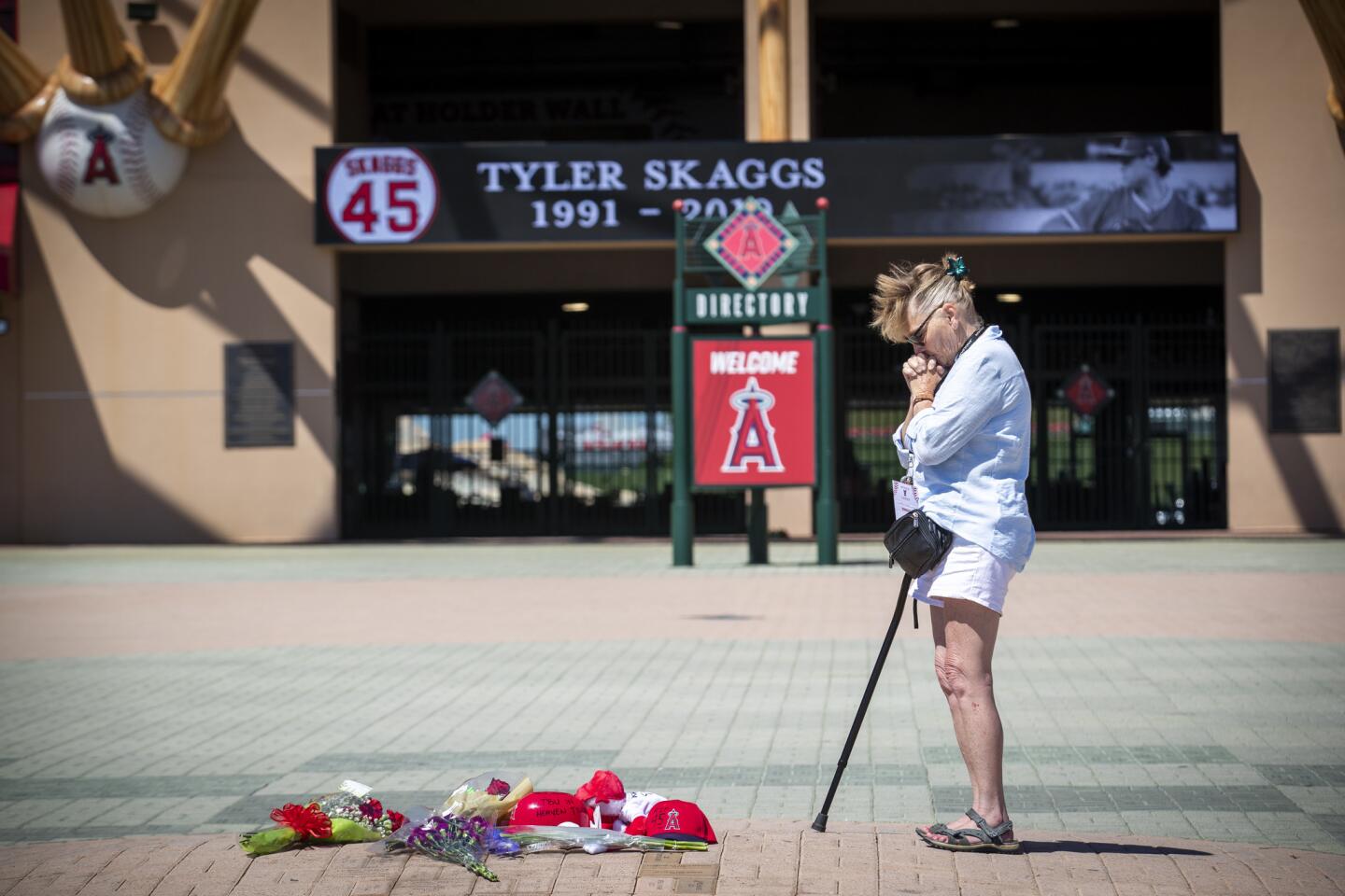 Angels fan Nancy Dodson of Garden Grove spends a quiet moment by herself at a growing memorial for Tyler Skaggs at Angel Stadium.