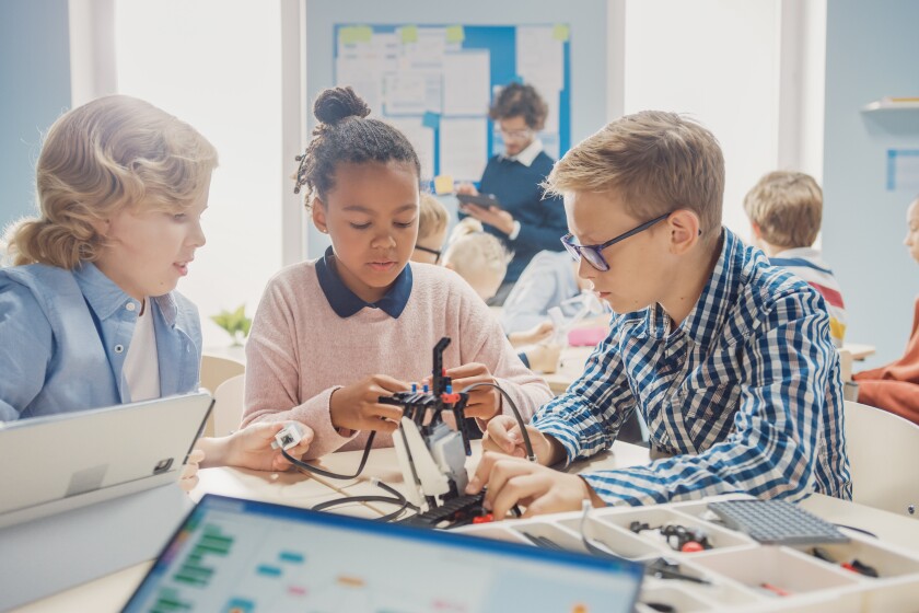 Elementary School Robotics Classroom: Diverse Group of Brilliant Children with Enthusiastic Teacher Building and Programming Robot. Kids Learning Software Design and Creative Robotics Engineering