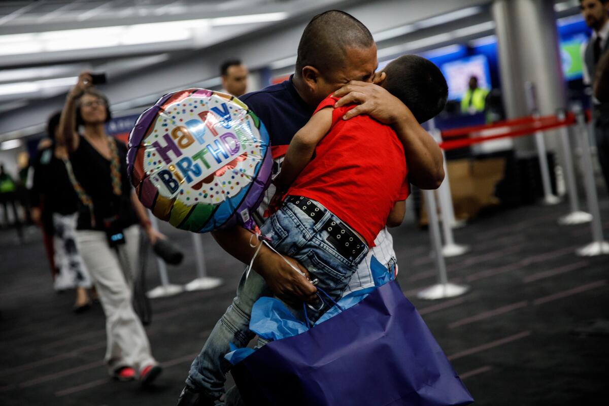 Guatemalan asylum seeker Hermelindo Che Coc embraces his 6-year-old son, Jefferson Che Pop, after reuniting with him at LAX.