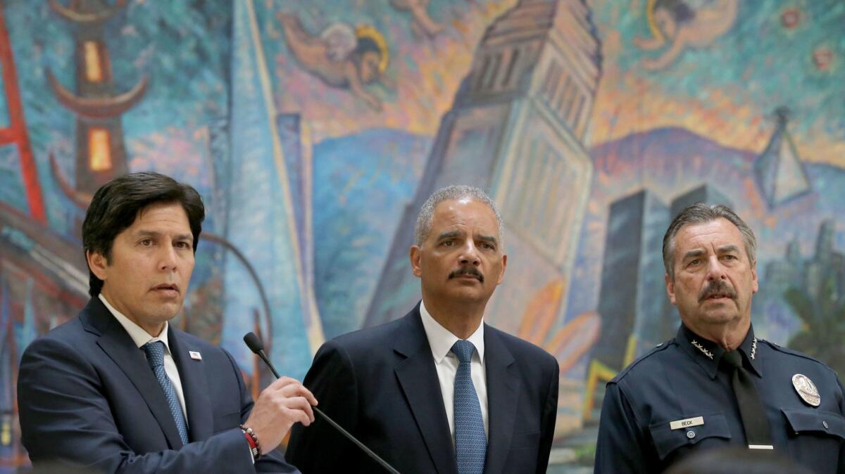 Senate leader Kevin de León, left, answers questions during a news conference to address the so-called sanctuary state bill while Former U.S. Atty. Gen. Eric Holder, center, and LAPD Chief Charlie Beck listen. (Allen J. Schaben / Los Angeles Times)