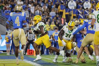 UCLA safety Bryan Addison watches Oregon running back Jordan James score a touchdown at the Rose Bowl in Pasadena