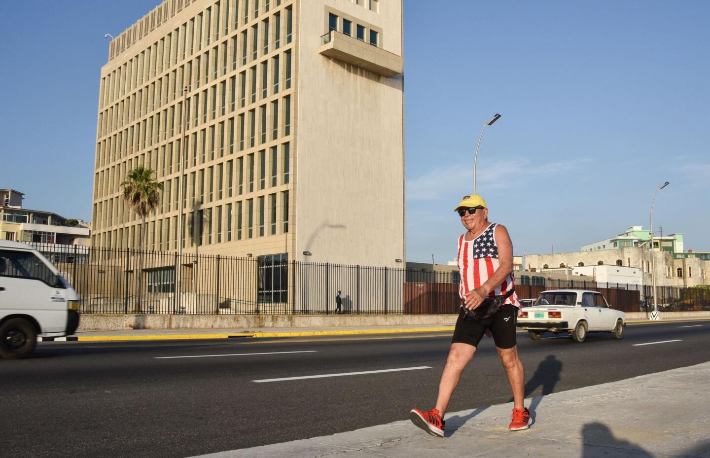 A man wearing a sleeveless shirt with the U.S. flag walks along the Malecon seafront in Cuba near the U.S. Embassy on July 20, 2015.