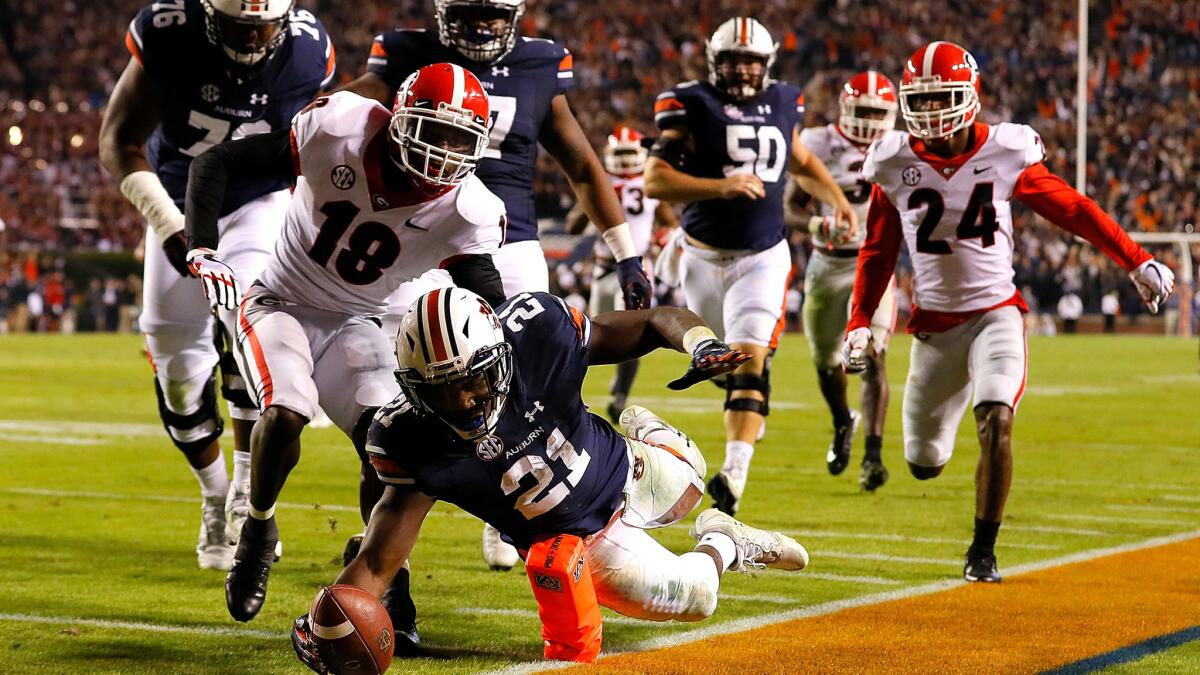 Auburn running back Kerryon Johnson dives for a touchdown past Georgia's Deandre Baker during the Tigers' upset Saturday.