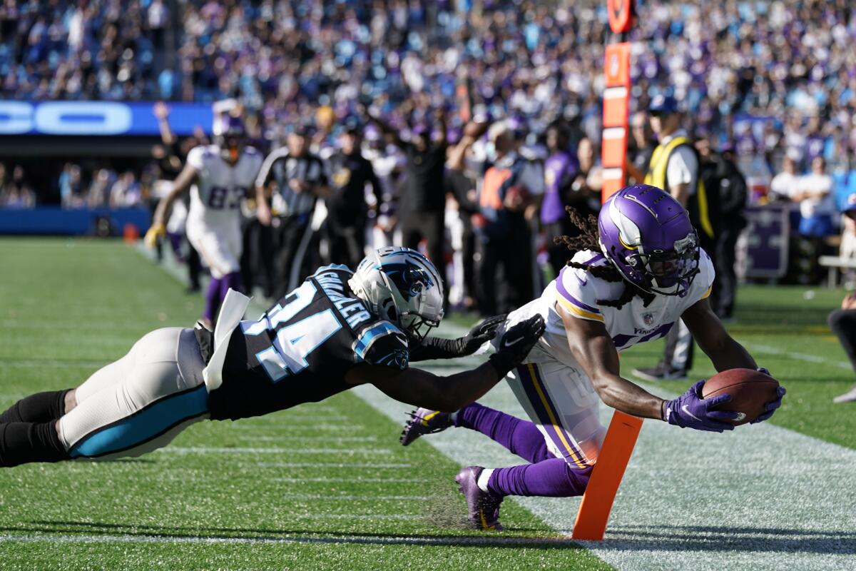 Minnesota Vikings wide receiver K.J. Osborn (17) makes the game-winning catch against Carolina Panthers safety Sean Chandler (34) during overtime of an NFL football game, Sunday, Oct. 17, 2021, in Charlotte, N.C. The Minnesota Vikings won 34-28. (AP Photo/Gerald Herbert)