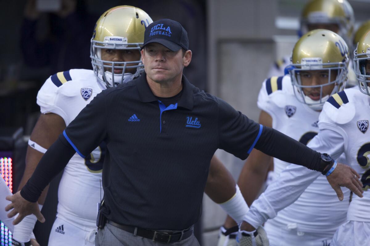 UCLA Coach Jim Mora waits to take the field with his Bruins team before a game against the Washington Huskies on Nov. 8.