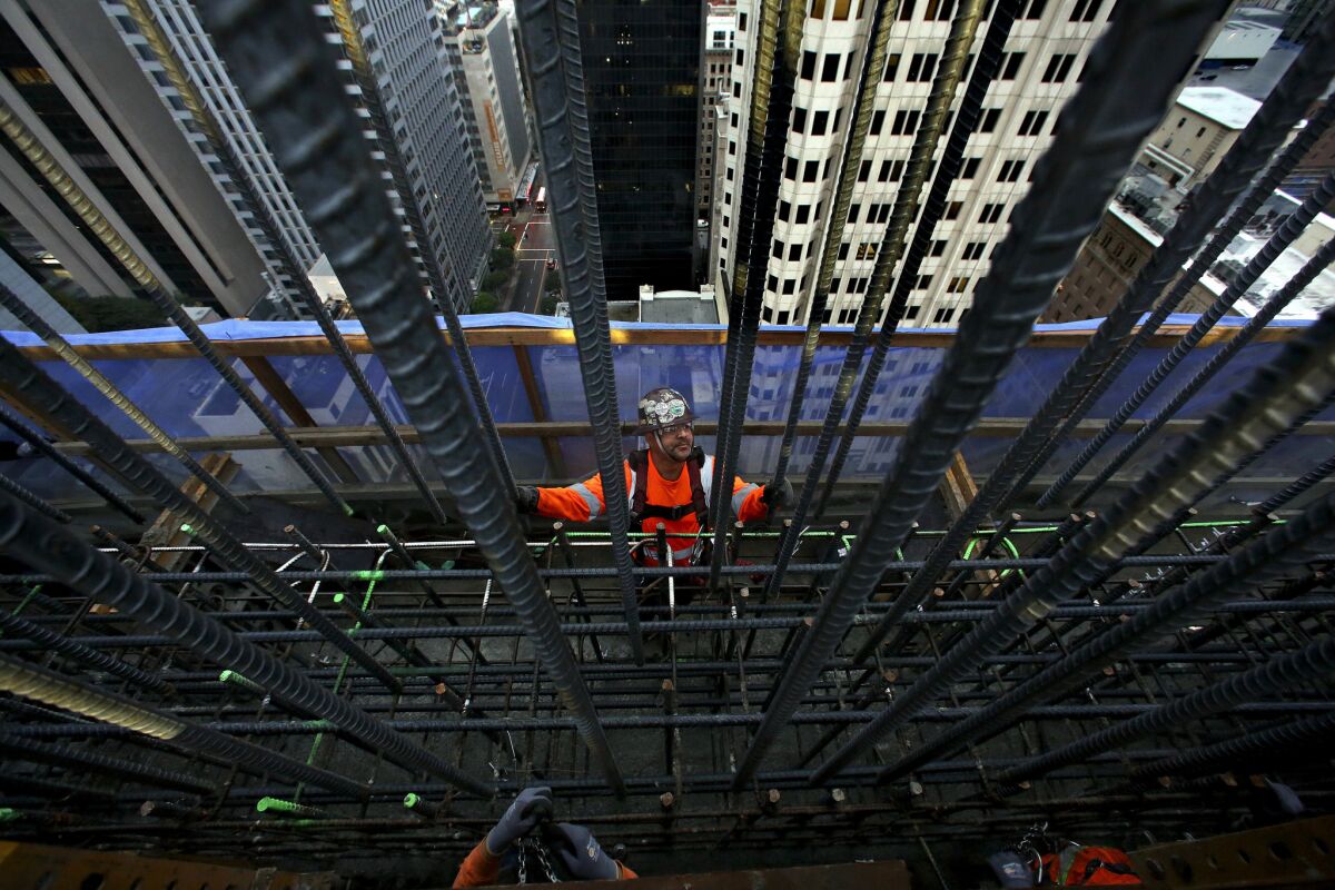 Iron worker Javier Jimenez guides a rebar wall into position.