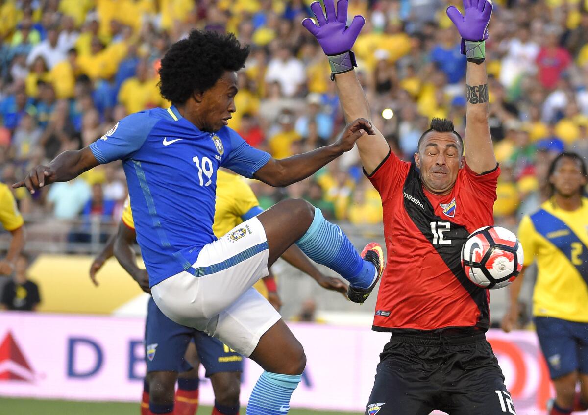 Brazil's Willian, left, has a shot blocked by Ecuador goalkeeper Esteban Dreer.