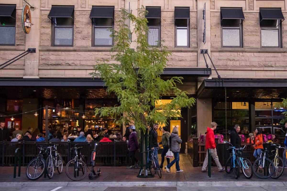 Pedestrians and diners on outdoor patios at Bittercreek Ale House and Diablo & Sons Saloon along 8th Street in Boise, Idaho.